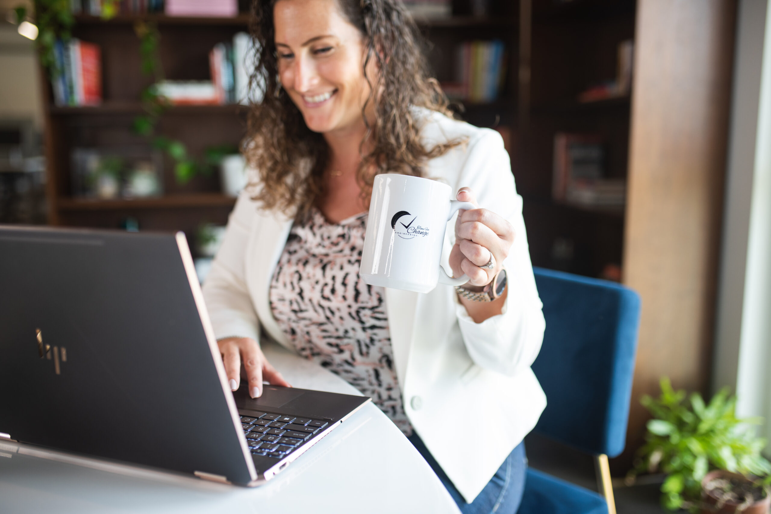 Cassandra at her computer with coffee in hand, ready to conquer the day! 